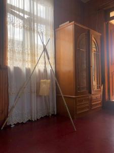 een statief leunend tegen een raam naast een dressoir bij Дом Бобоквати in Kobuleti