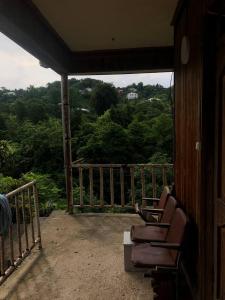 een veranda met stoelen en uitzicht op de bomen bij Дом Бобоквати in Kobuleti