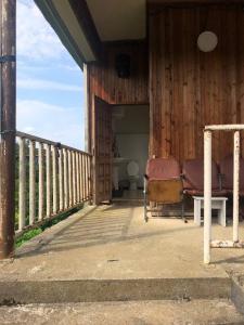 een veranda van een houten huis met een stoel bij Дом Бобоквати in Kobuleti