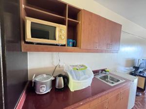 a kitchen counter with a microwave and a sink at Alta Vista De Boracay, 109B in Boracay