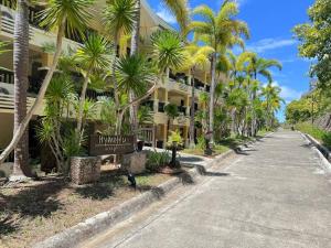 a street in front of a building with palm trees at Alta Vista De Boracay, 109B in Boracay