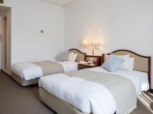 a hotel room with two beds and a telephone at Gran Palette Hakodate in Hakodate
