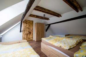 a bedroom with two beds in a attic at Statek DĚRAVÁ BOTA in Benešov nad Černou