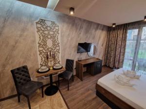 a room with a bed and a table and chairs at Mit Prot Panorama Bay 2 luks Studio 40 in Sveti Vlas