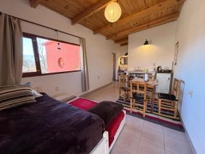 a bedroom with a bed and a kitchen in it at LA MULITA HUMAHUACA in Humahuaca