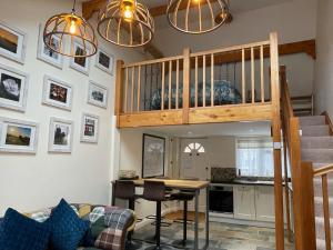 a living room with a loft bed and a kitchen at Harvest Moon Cottage in Bishops Frome