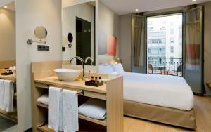 a hotel room with two beds and a mirror at Hotel Àmbit Barcelona in Barcelona