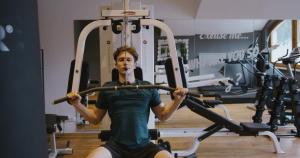 a woman is sitting on a gym machine at MANNI das Hotel in Mayrhofen