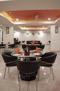 a dining room with black chairs and tables at Hotel Livbox in Dehradun