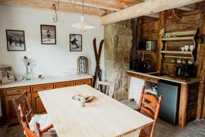 a kitchen with a wooden table and a table and chairs at Domek Przyjacielówka Ekstra -Miejsce Ciszy in Sienna