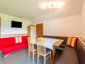 a dining room with a table and chairs and a couch at Apartment in Tyrol near Ski Lift in Fügen