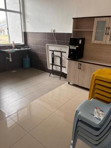 Habitación con cocina con mesa y silla. en Lily's Homestay, en Jerantut
