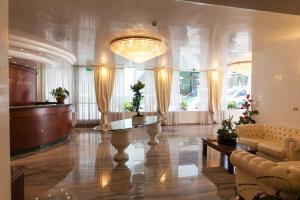 a lobby with a table and a chandelier at Hotel Ambassador in Rimini