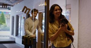 a woman holding a dog in front of a mirror at MANNI das Hotel in Mayrhofen