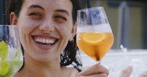 a woman is holding up a glass of beer at MANNI das Hotel in Mayrhofen