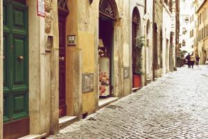 a cobblestone street with a green door on a building at La Casetta di Zio Mario in Rome