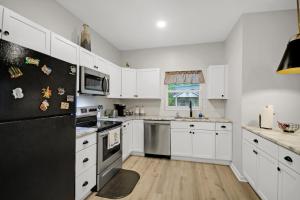 a kitchen with white cabinets and stainless steel appliances at Near Park Circle, Downtown, And Beaches in Charleston