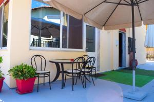 a patio with a table and chairs and an umbrella at Agyra Villa in Limenaria