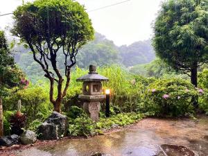 逗子市山に囲まれた隠れ和式庭園室外bbq的花园中央有一座石灯笼