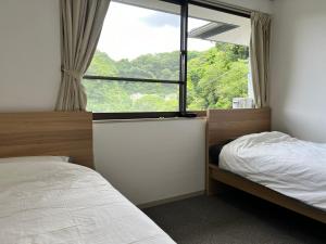 逗子市山に囲まれた隠れ和式庭園室外bbq的一间带床和大窗户的卧室