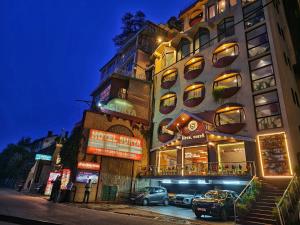 a tall building with cars parked in front of it at Hotel Surya Shimla in Shimla