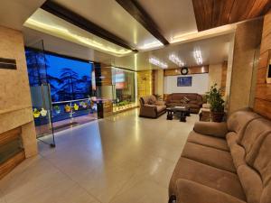 a large living room with couches and a large window at Hotel Surya Shimla in Shimla