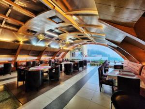 a dining room with tables and chairs and a large window at Hotel Surya Shimla in Shimla