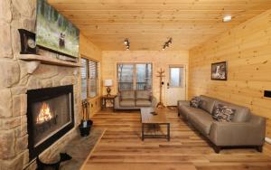 a living room with a fireplace in a log cabin at Hot tub and game room! - Black Bear Crossing in Gatlinburg