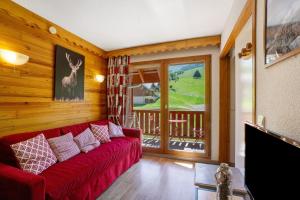 a living room with a red couch and a balcony at A3 405 Appart au pied des pistes in Saint-François-Longchamp