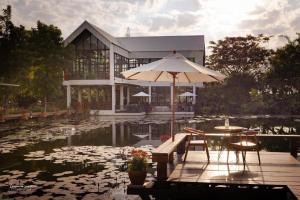 a building with an umbrella next to a pond of lilies at TakFha Café & Resort in Ban Tha Ngam (1)