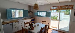 a kitchen with blue cabinets and a table with chairs at Ca la Yaya in Lliria
