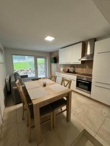 a kitchen with a wooden table and chairs in it at Apartmán Komenského 14 in Prievidza