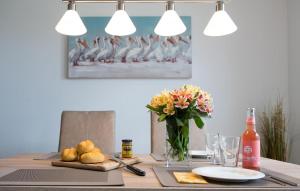 a table with a vase of flowers and a vase of bread at Happy Holidays in Olpenitz