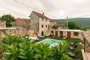 an external view of a house with a swimming pool at Villa Stone Valcer in Slivno