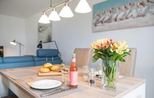 a table with a vase of flowers and a bottle of wine at Happy Holidays in Olpenitz