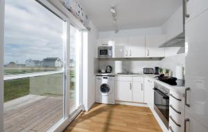 a kitchen with white cabinets and a large window at Happy Holidays in Olpenitz +18 photos