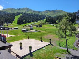 a view of a park with mountains in the background at LE LIORAN appartement vue face à la montagne au pied des pistes in Laveissière