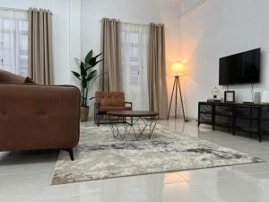 a living room with a couch and a table and a television at Nick Cozy Homestay 1st Floor in Jeli