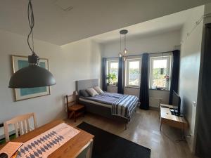 a living room with a bed and a table at Newly built bright apartment, close to everything If you want to visit Stockholm, you will find the perfect accommodation here! Ferry line 80 makes it very convenient and easy to get to the city center in Nacka