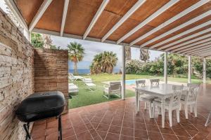 a patio with a grill and a table and chairs at Villa Cassis in Adeje