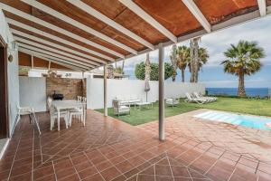 a patio with a table and chairs and a pool at Villa Cassis in Adeje
