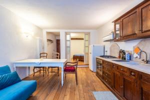 une cuisine avec une table et un canapé bleu dans l'établissement Appartamento nel cuore di Volterra, à Volterra