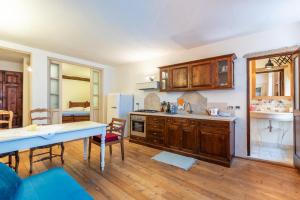 une cuisine avec des armoires en bois et une table à l'intérieur dans l'établissement Appartamento nel cuore di Volterra, à Volterra