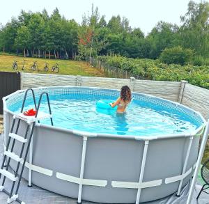 a little girl is sitting in a hot tub at Pensiunea Fira in Baia de Fier