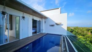 a villa with a swimming pool and a house at Villa Omah Bali in Uluwatu