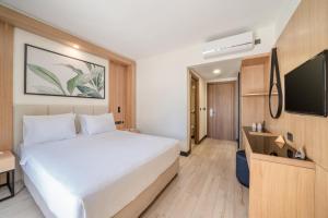 a hotel room with a bed and a flat screen tv at Sundia By Liberty Oludeniz in Oludeniz