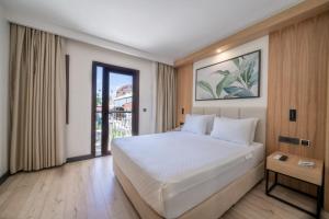 a bedroom with a large white bed and a window at Sundia By Liberty Oludeniz in Oludeniz