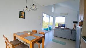 a dining room and living room with a table and chairs at Villa Omah Bali in Uluwatu