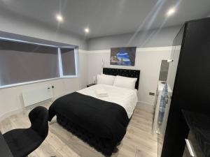 海斯Letzi Premium Cozy Retreat Private En-Suite Rooms, Heathrow Airport的一间卧室配有一张大床和黑色毯子