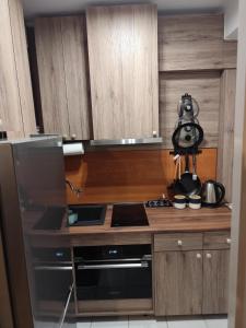 a kitchen with wooden cabinets and a stove top oven at Mroczne marzenie in Przemyśl +16 photos